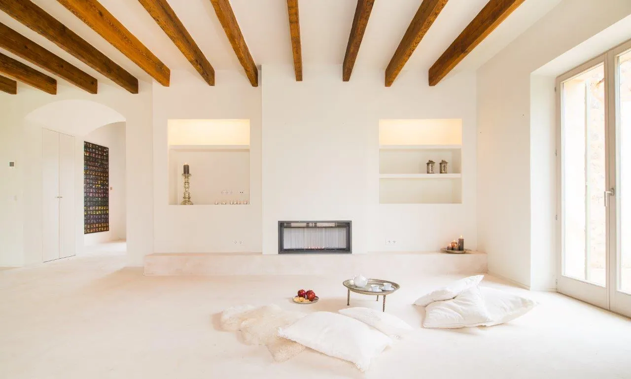 White living room with wooden beams and fireplace